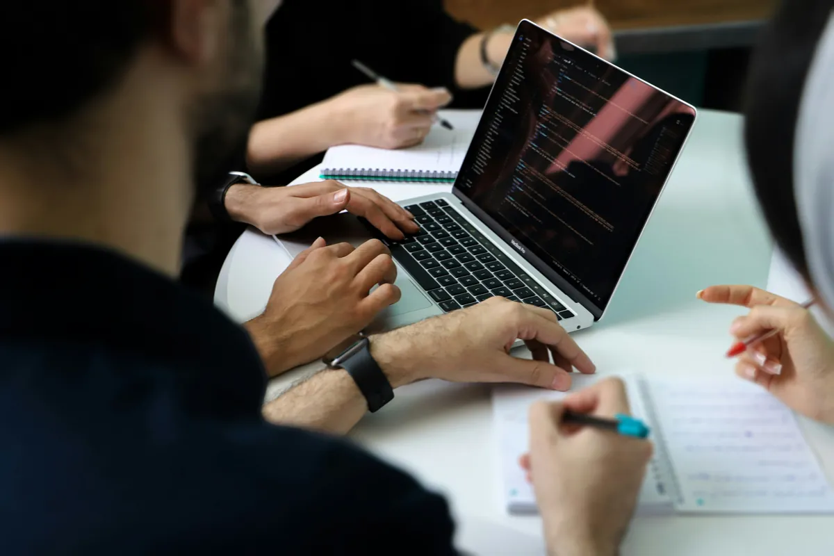 Team working together around a laptop and notebooks